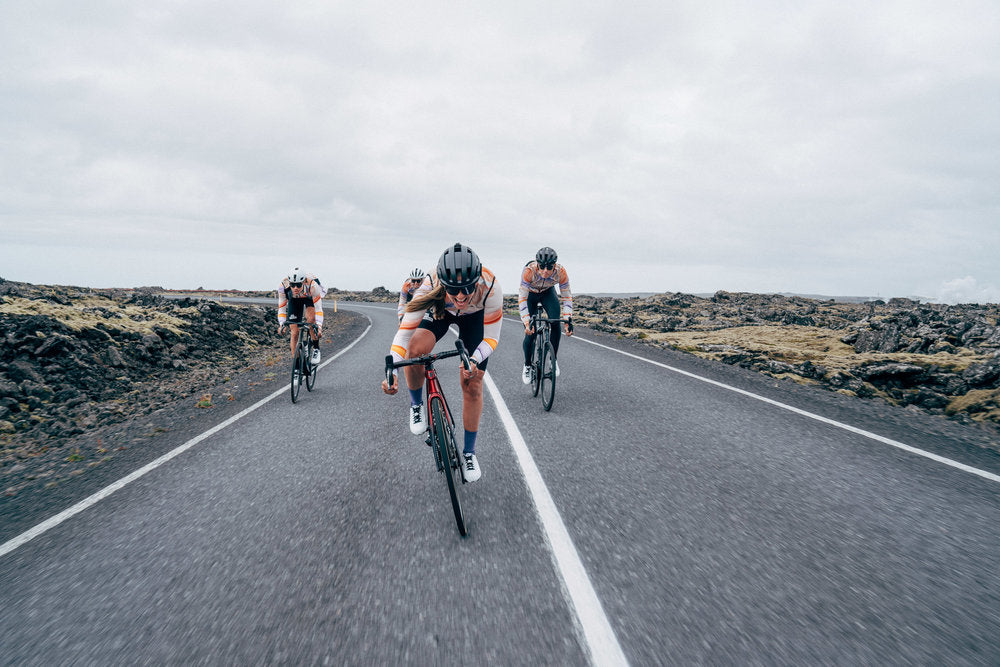 Group ride along a coastal road highlighting Bici's comprehensive cycling FAQs @ Bici.