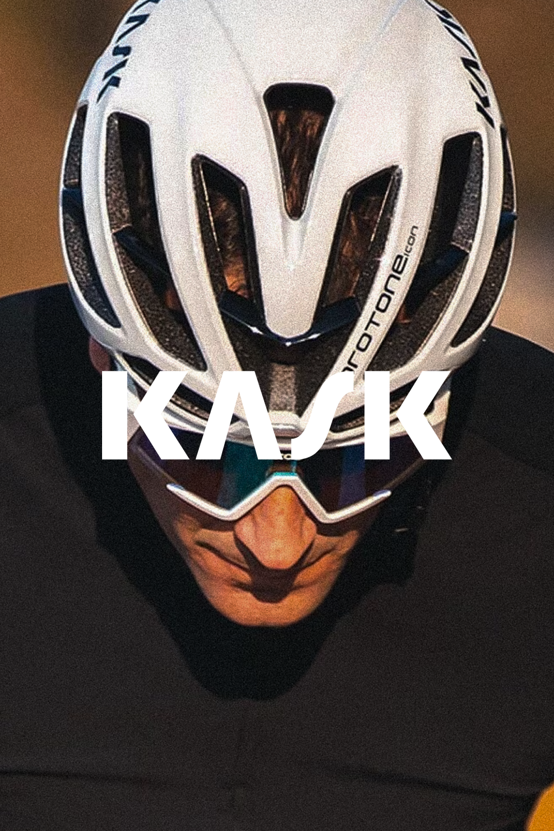 Cyclist looking downwards, featuring the aerodynamic design of a white KASK helmet @ Bici.